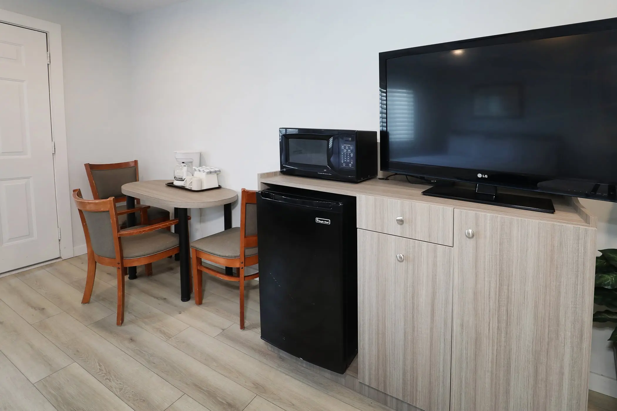 The microwave, small beverage fridge and TV on a cabinet in a Type 10 Townhouse Motel Room at the Matador