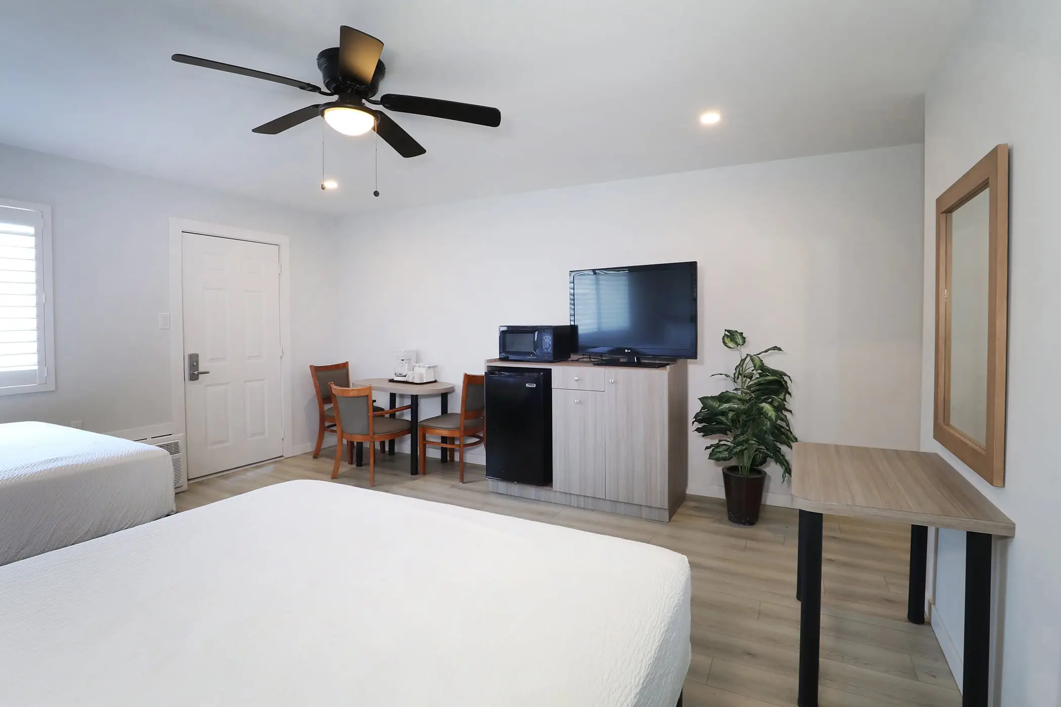 A Type 10 Townhouse Motel Room at the Matador seen from beside the beds, looking toward the door, table and TV cabinet
