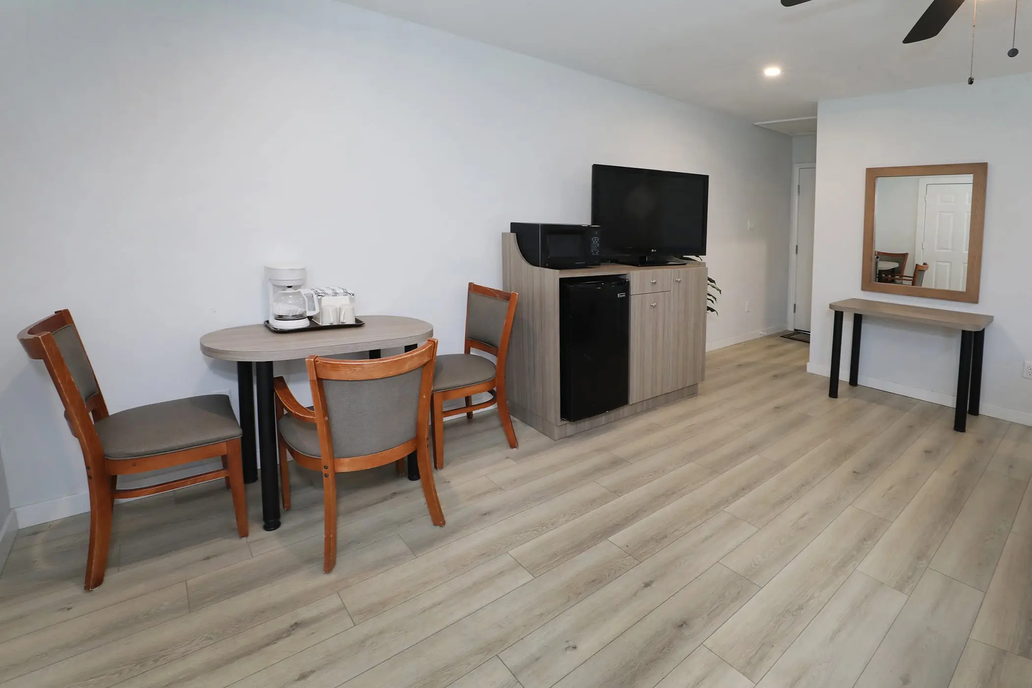 The small table and three chairs in a Type 10 Townhouse Motel Room at the Matador, with a coffee maker, beverage fridge and TV