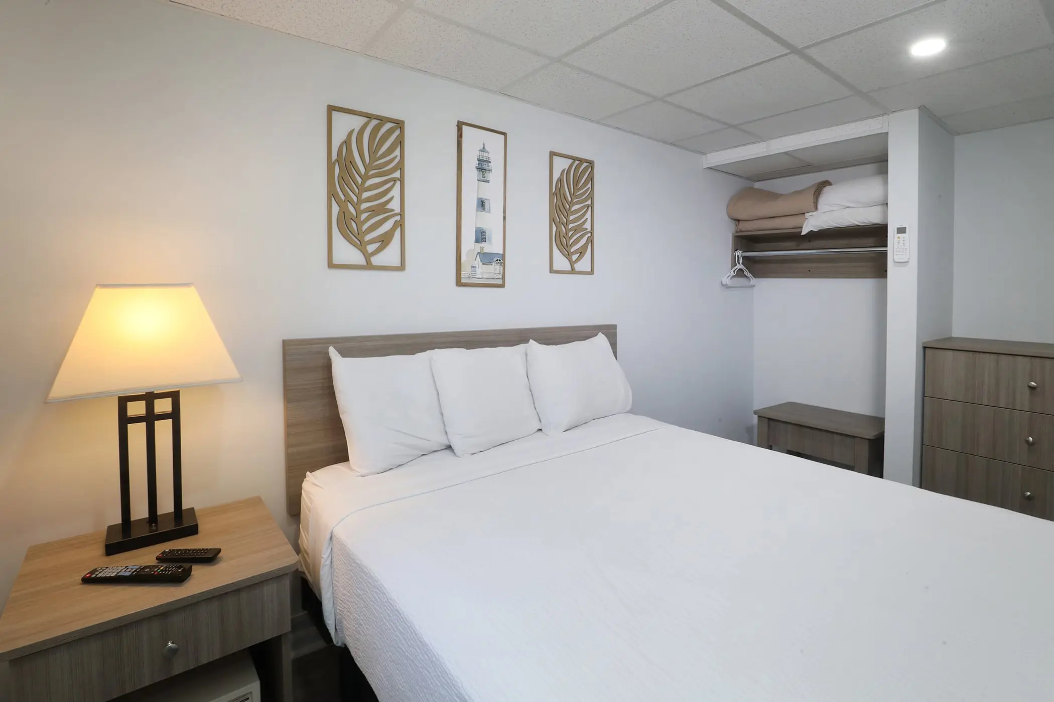The same Type 8 bedroom at the Matador from the doorway, showing the bed, nightstand and open wardrobe shelving