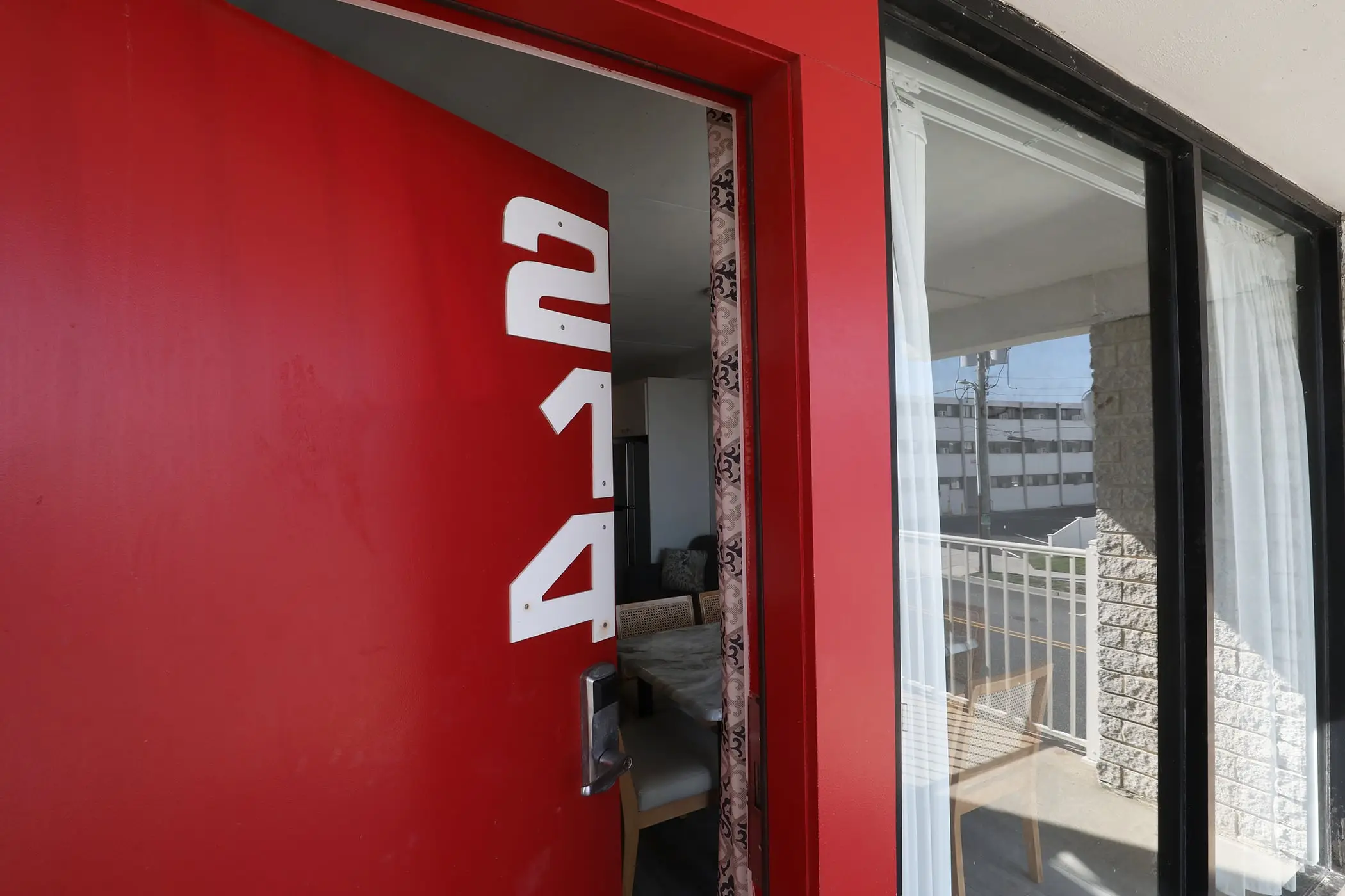 The red front door of unit 214, a Type 8 Two-Bedroom Unit at the Matador, open onto the living area